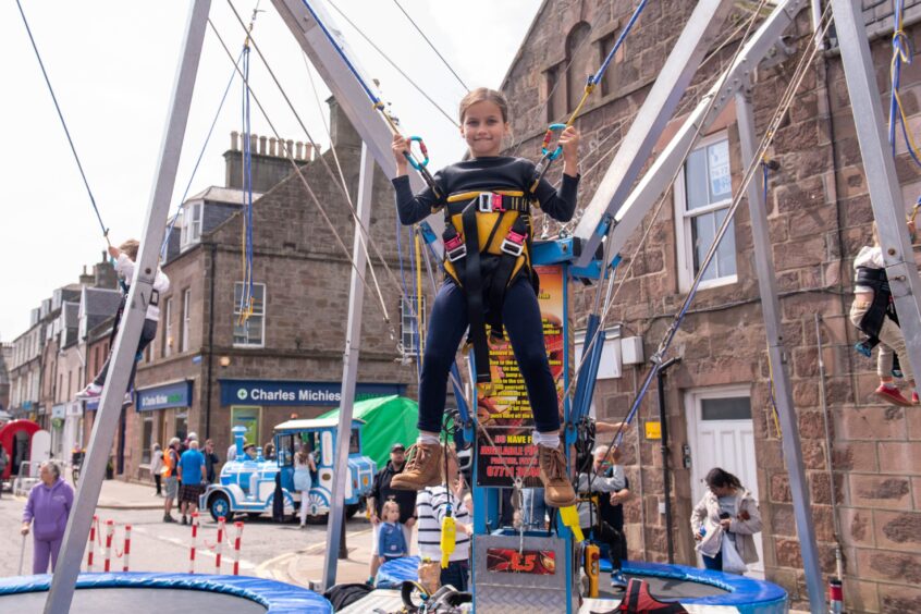 A child looks at the camera as she plays on the trampoline at the Feein' Market in Stonehaven.