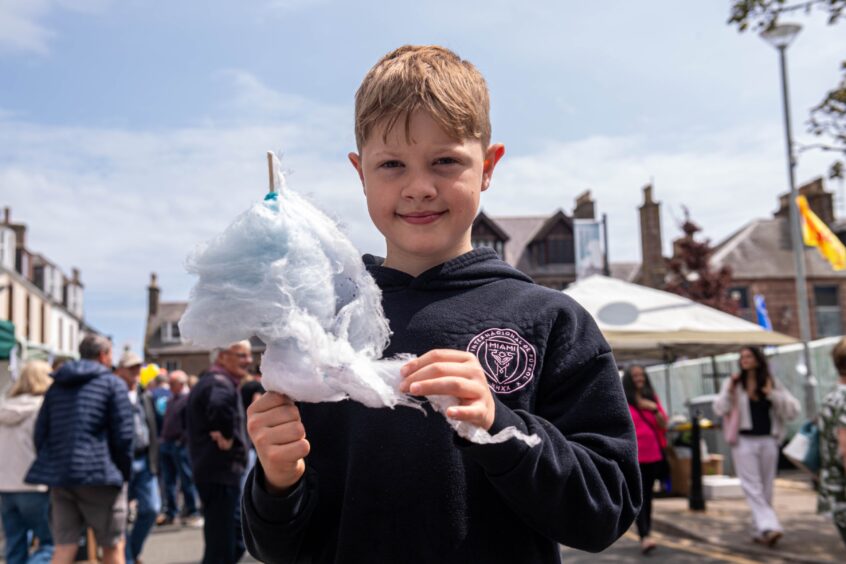 A boy holding some candy floss.
