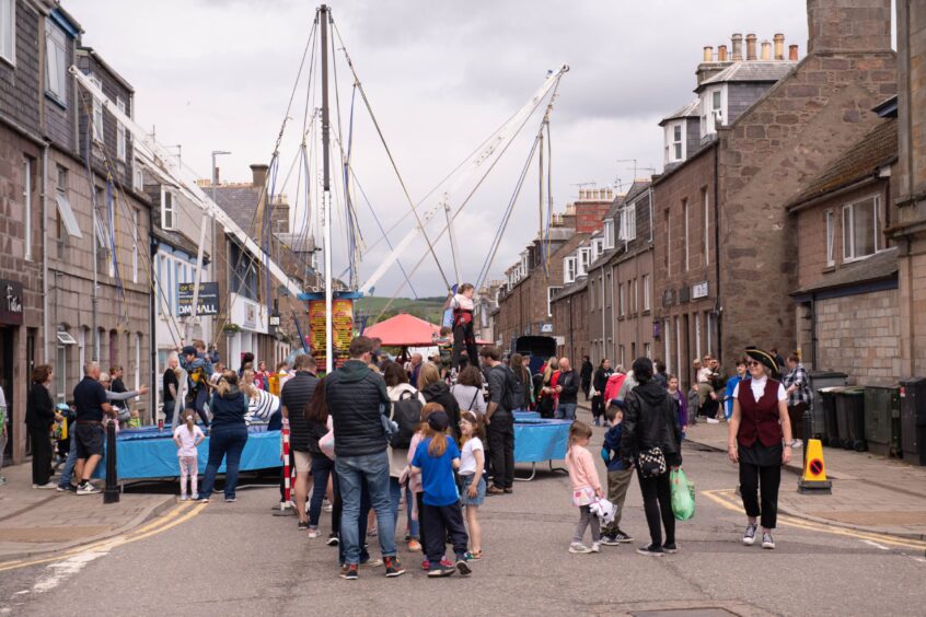 Children attached to a bungee harness jumping up and down.