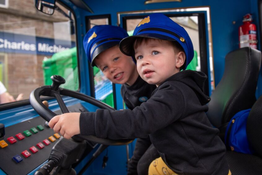 Two children sit at the wheel of the Stonehaven Land Train.
