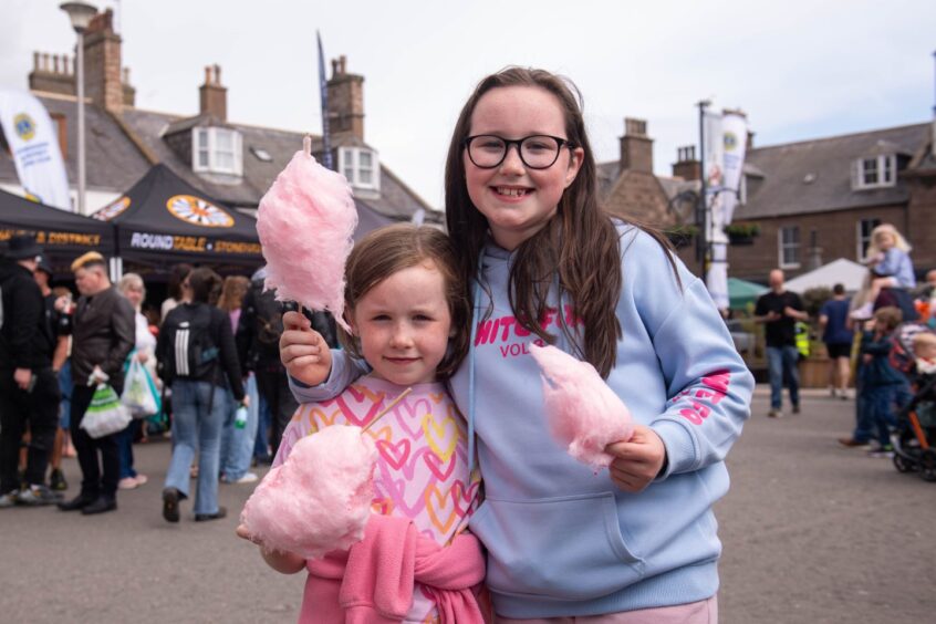 Two children holding candy floss.