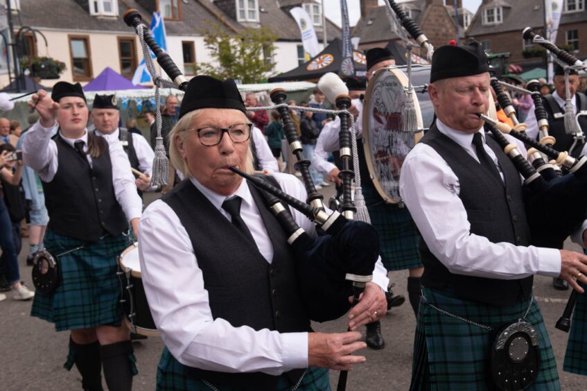 Pipers and drummers marching down the street at the Feein' Market in Stonehaven.