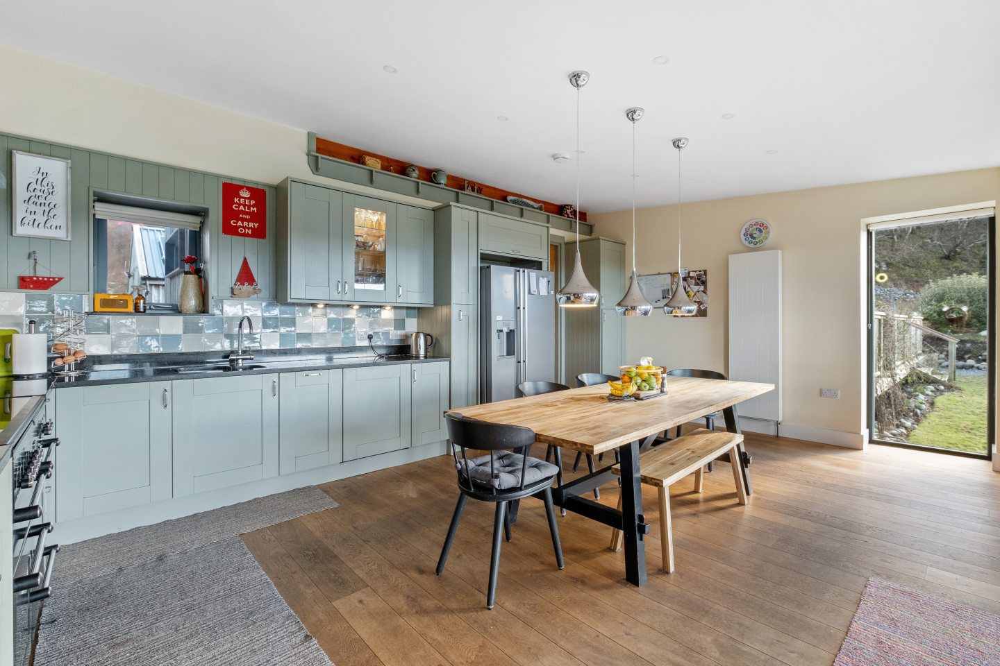 The contemporary kitchen with feature lighting over the dining space.