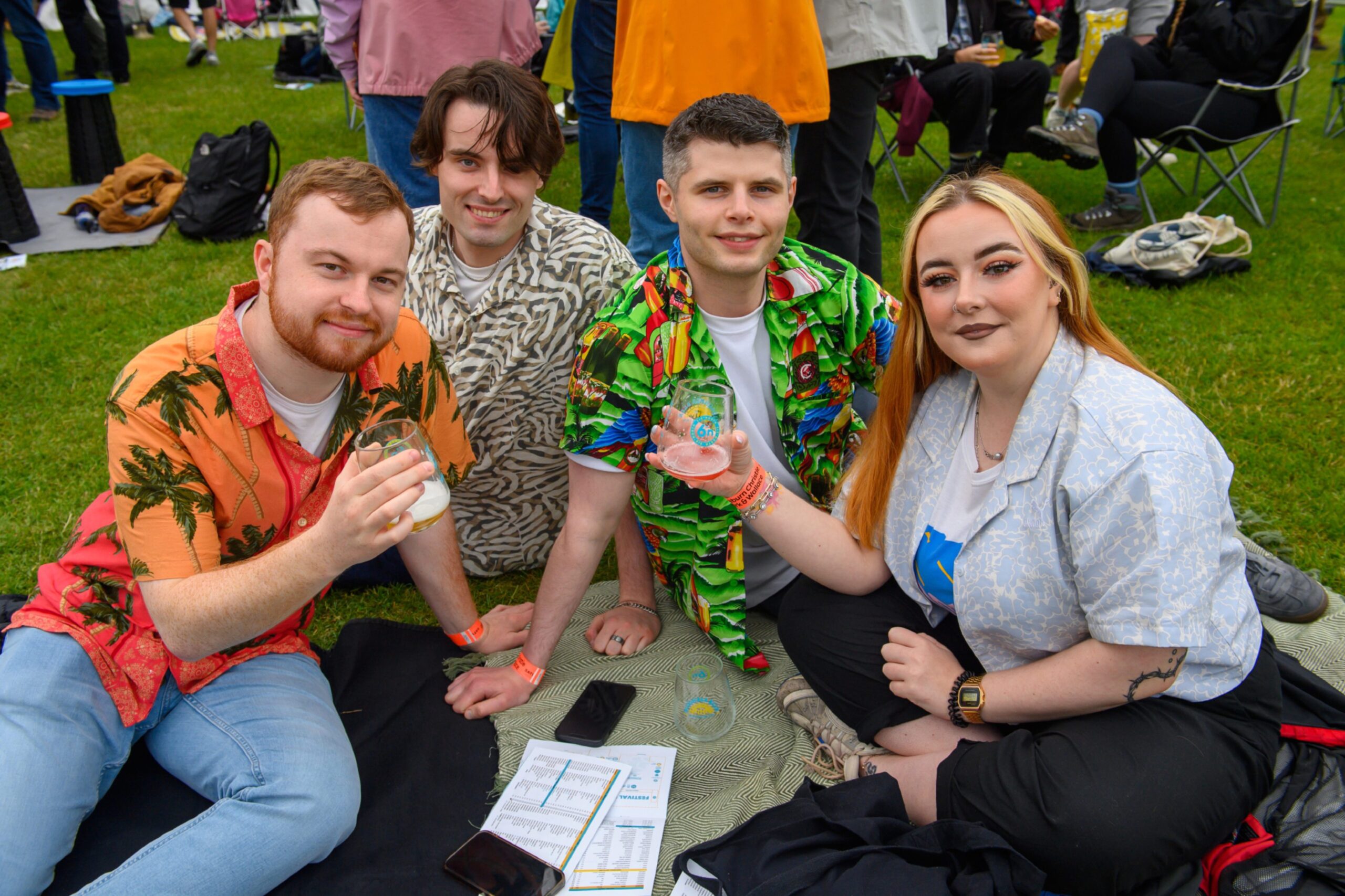 Four people sitting on a picnic blanket