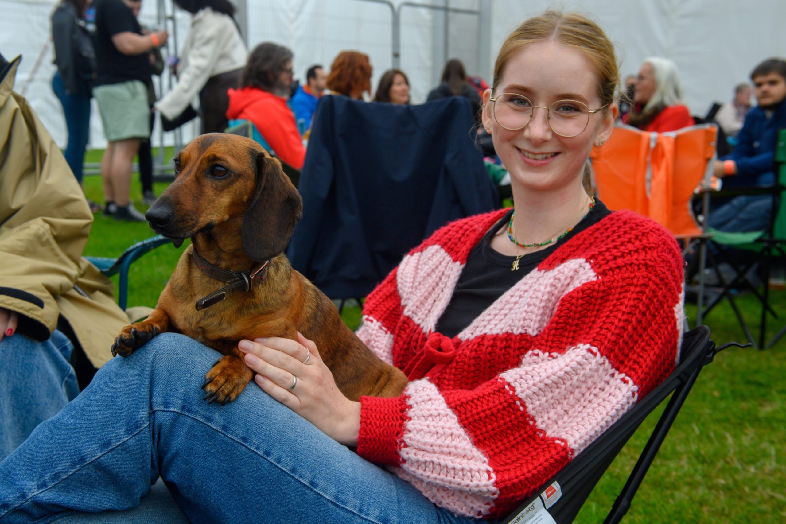 A woman sitting with a dachshund on her lap