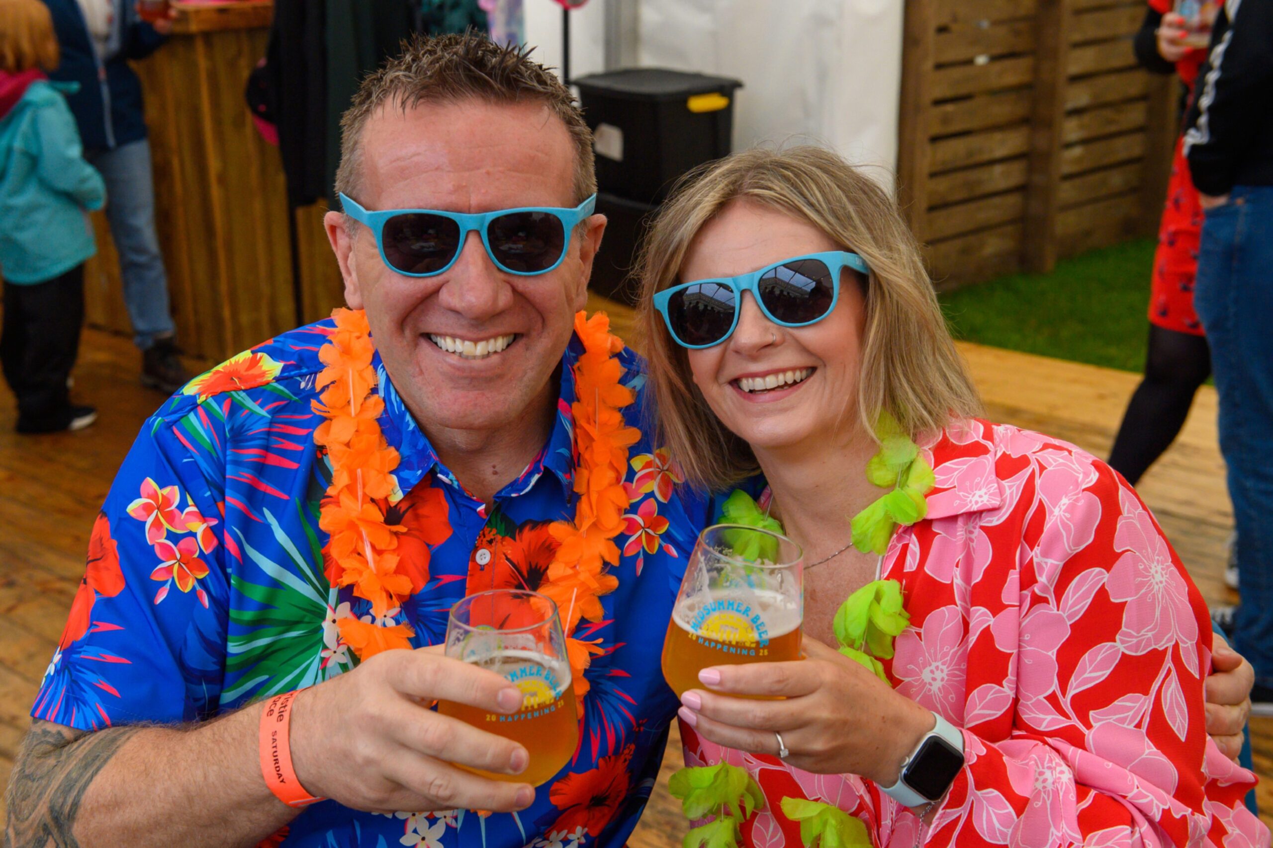A man and woman smiling with glasses of beer