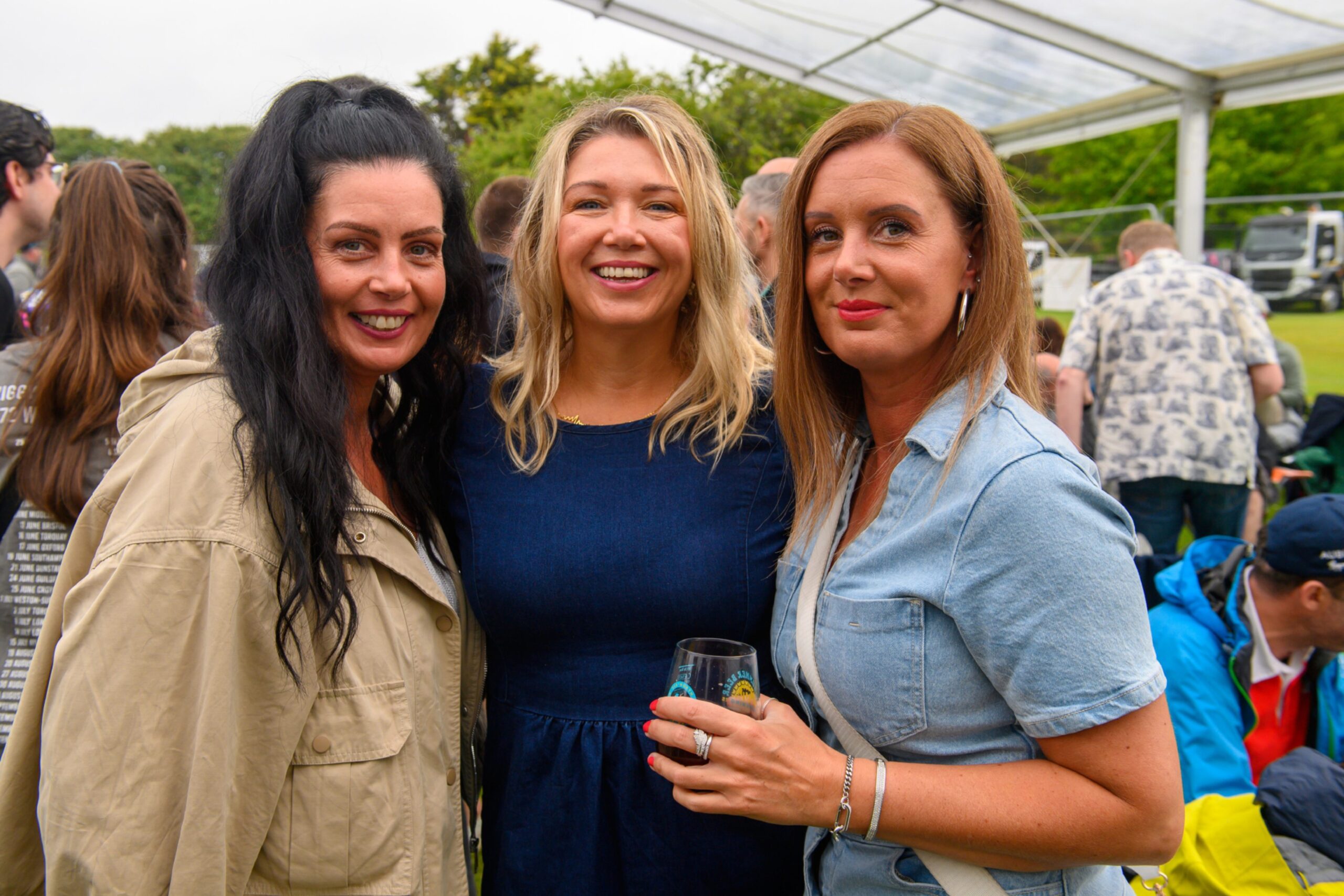 Three women smiling with beer