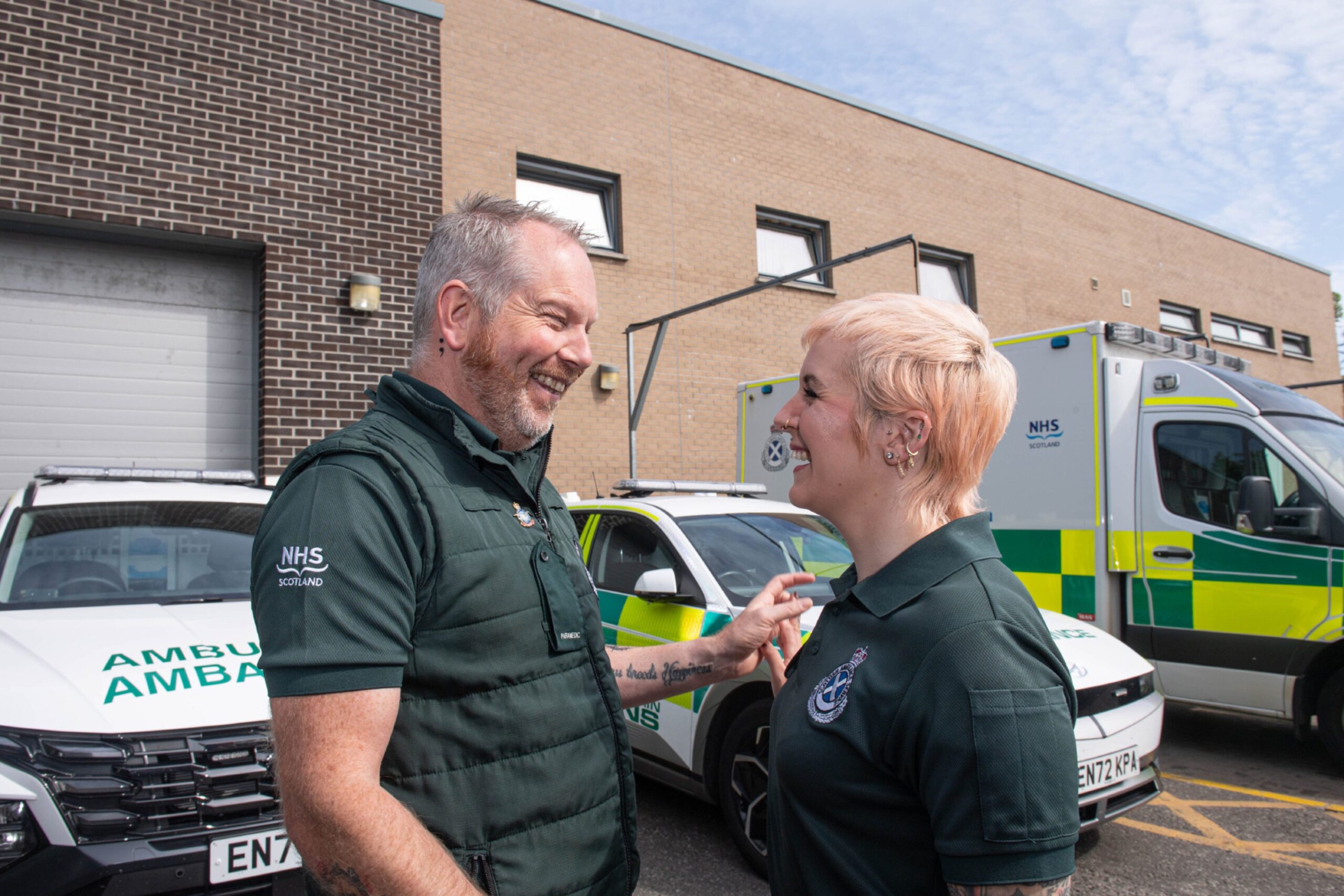 Stuart and Sarah in front of emergency vehicles.