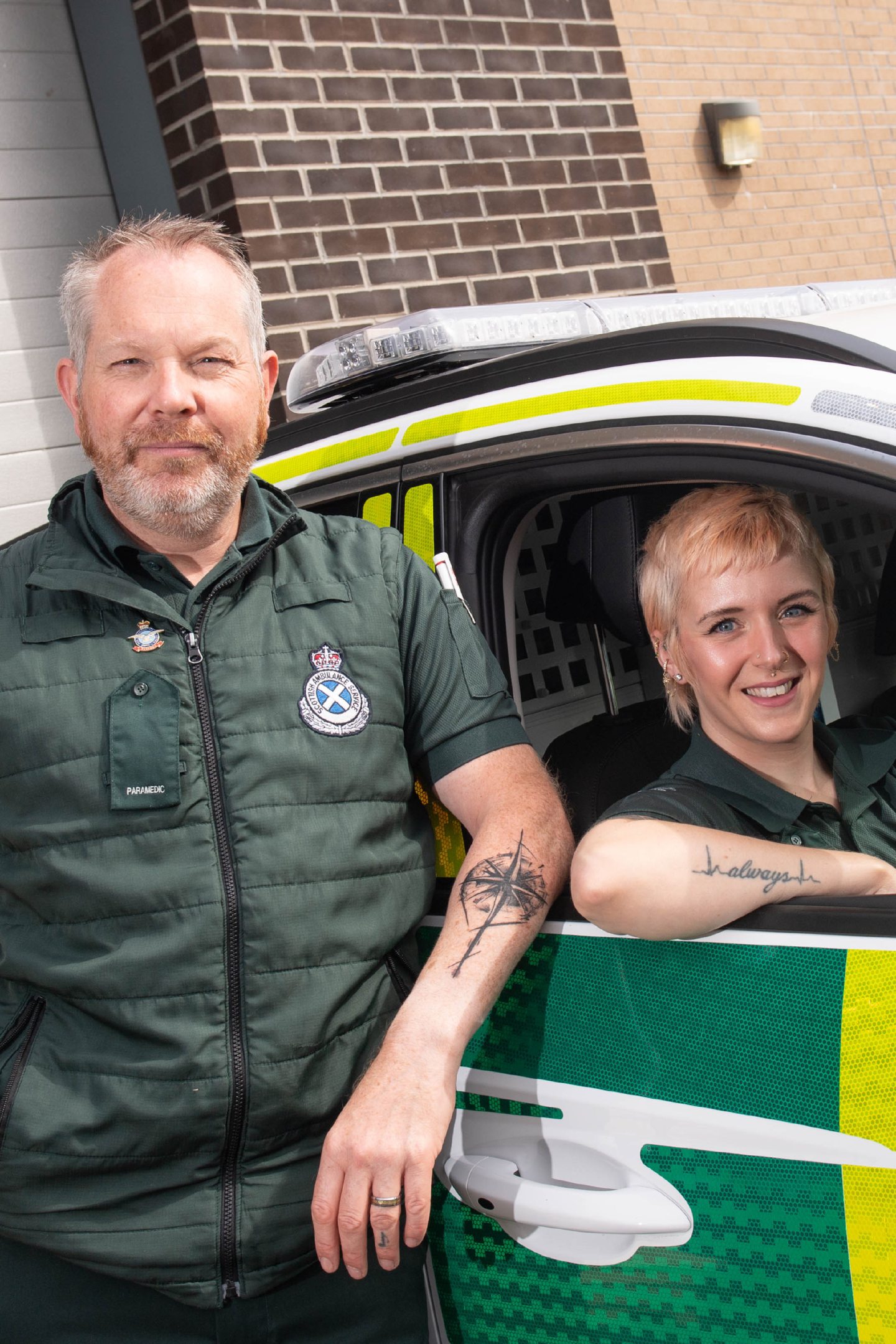 Sarah in the rapid response car with Stuart standing alongside.