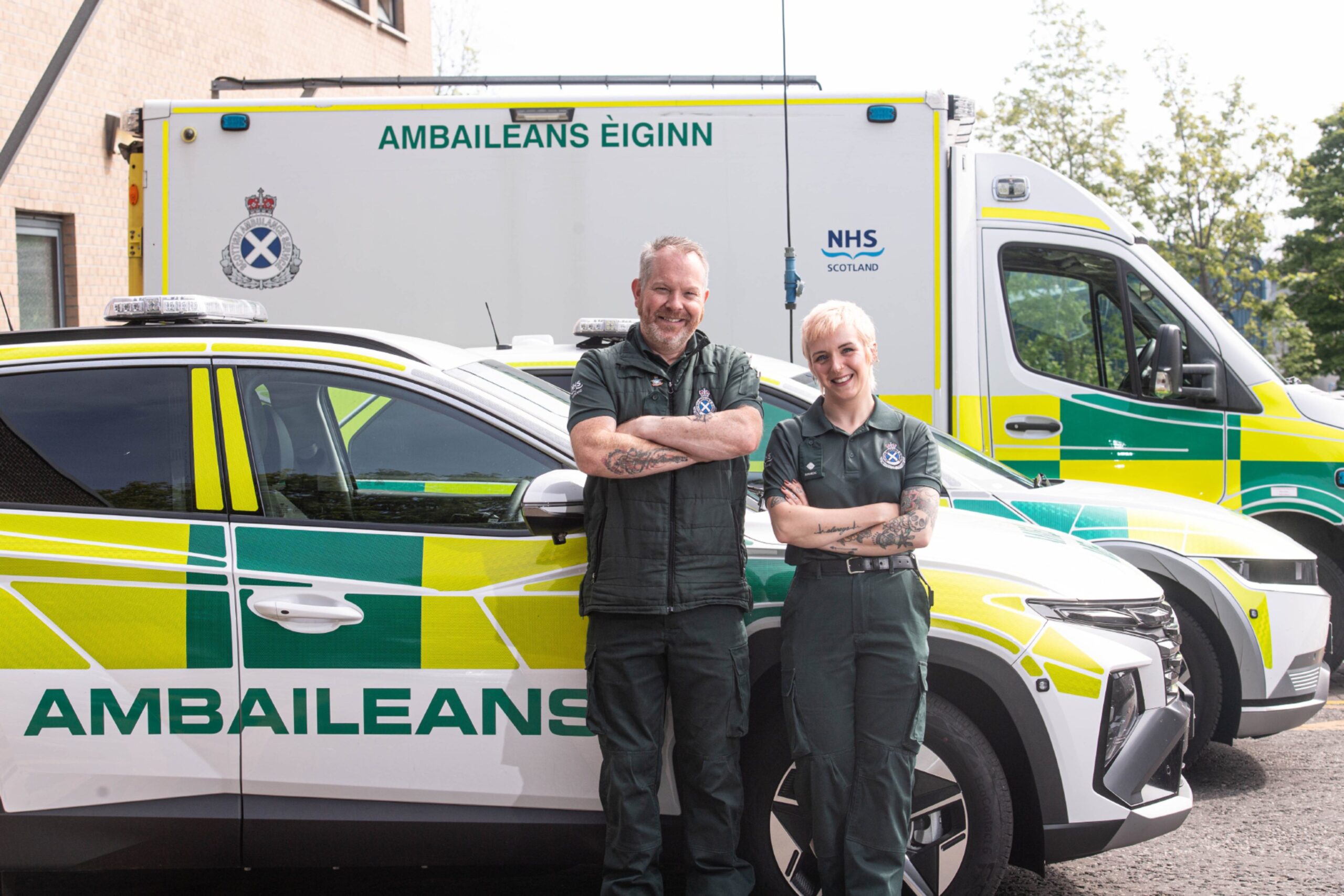 Stuart and Sarah in front of rapid response car and ambulance.