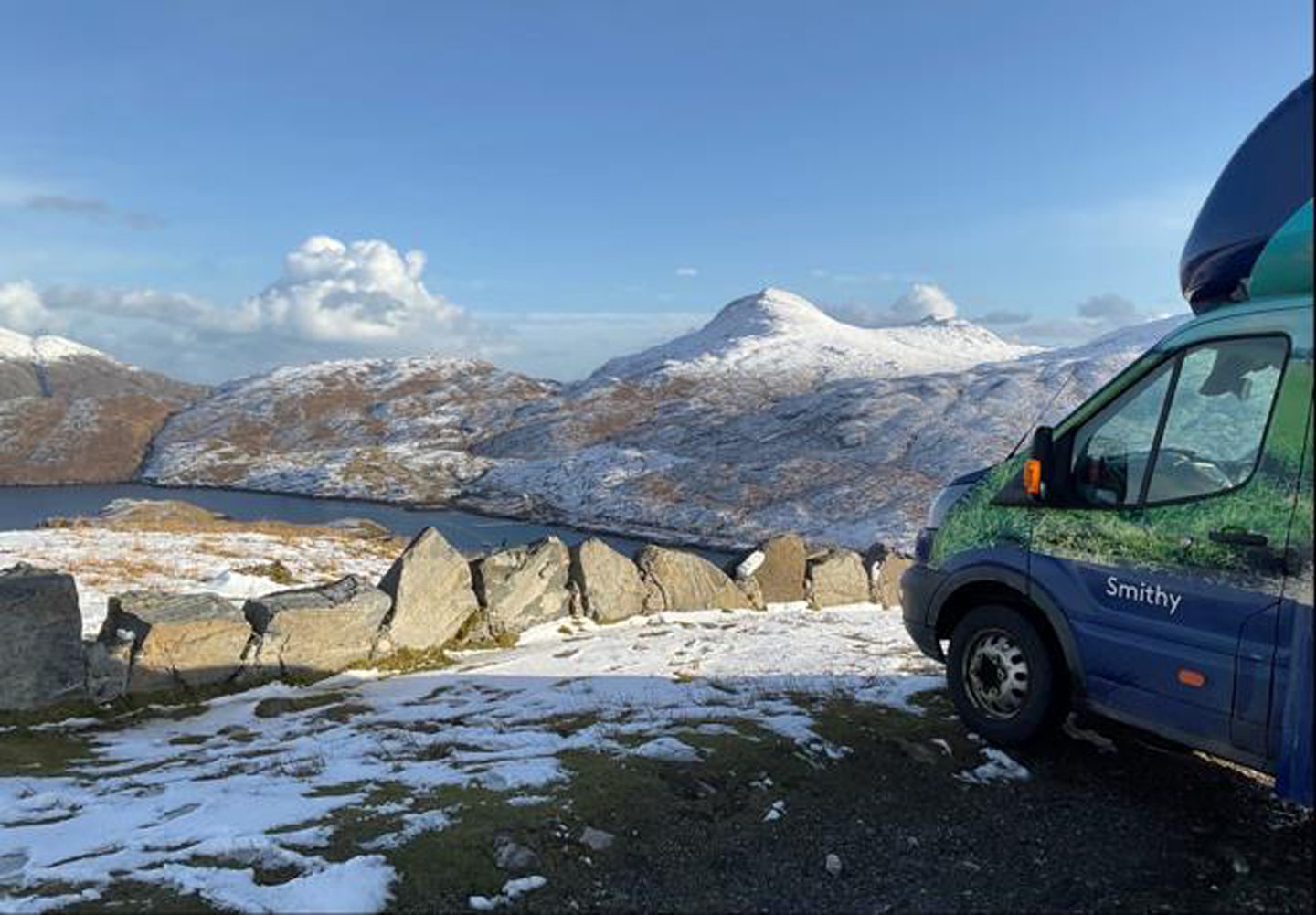 The mobile banking van with the snow-topped mountains of Lewis and Harris in the background.
