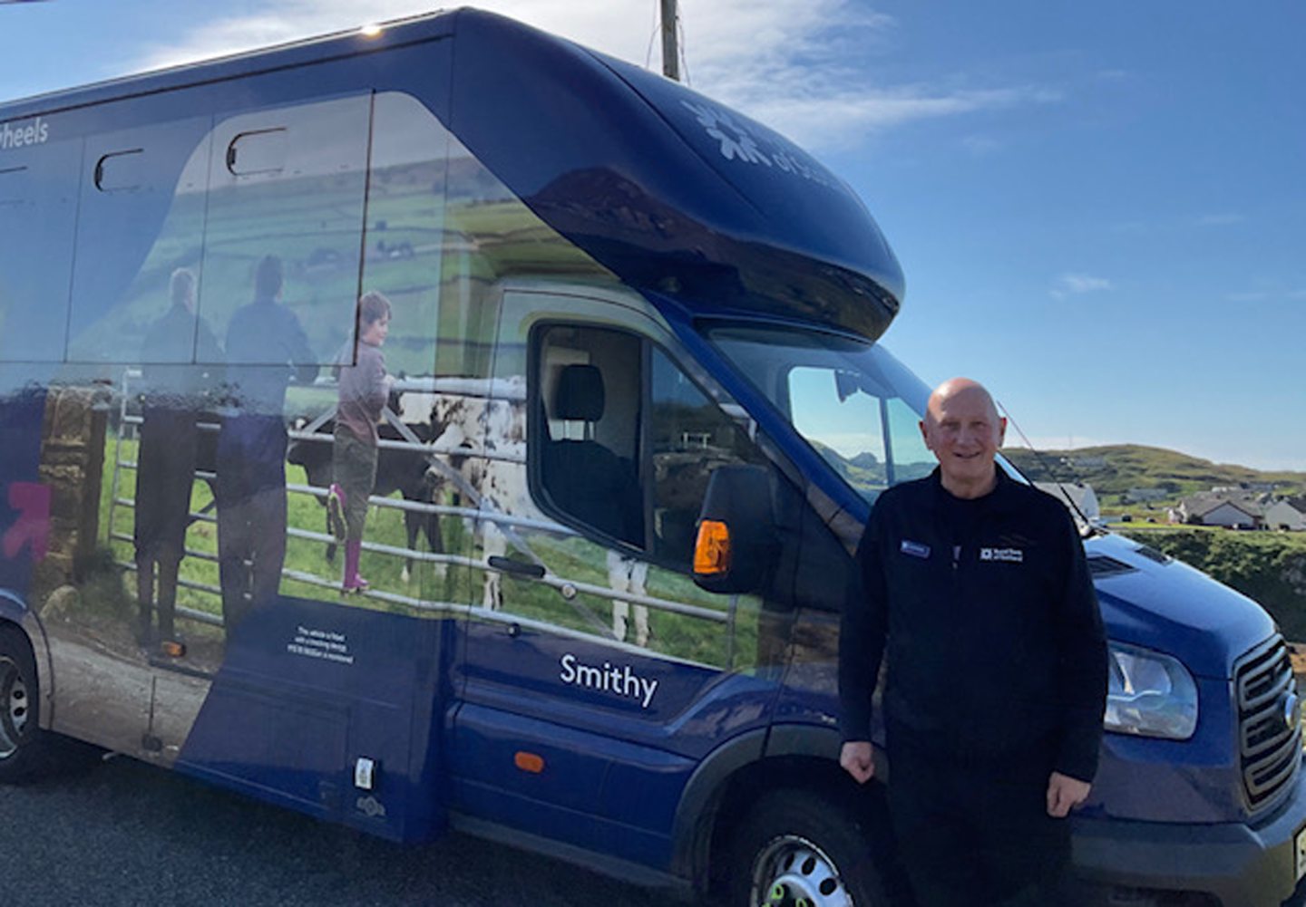 Ruaridh standing in front of the mobile banking van.