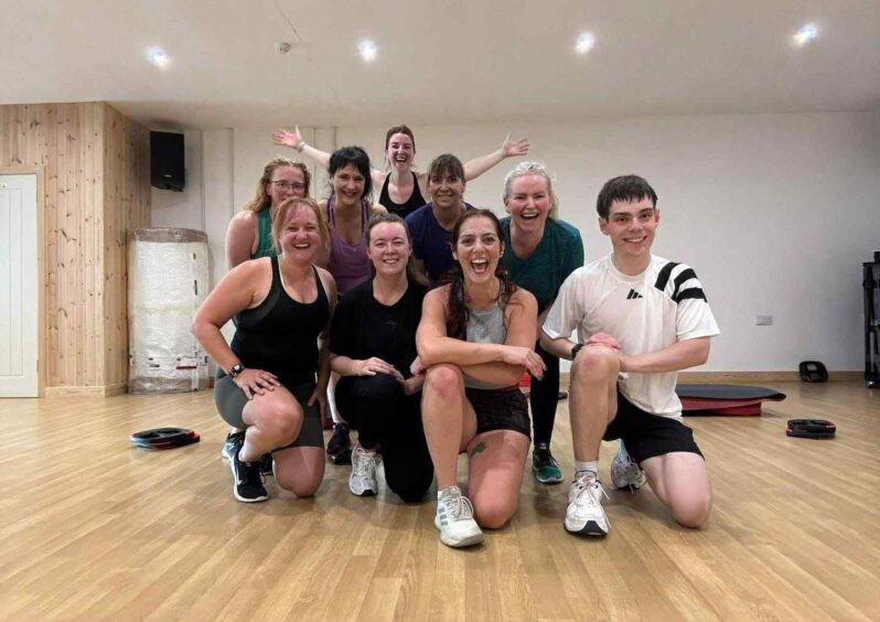 Nine people smiling at the Happy Wee Health Club, Oban.