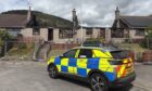 A police car outside the fire-hit homes in Ballater