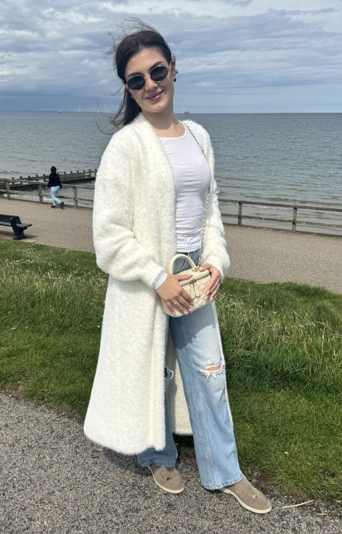 Valeriia Tsykalo at Aberdeen Beach describes her style to us. She's wearing light wash distressed jeans, a fluffy cream calf-length cardigan