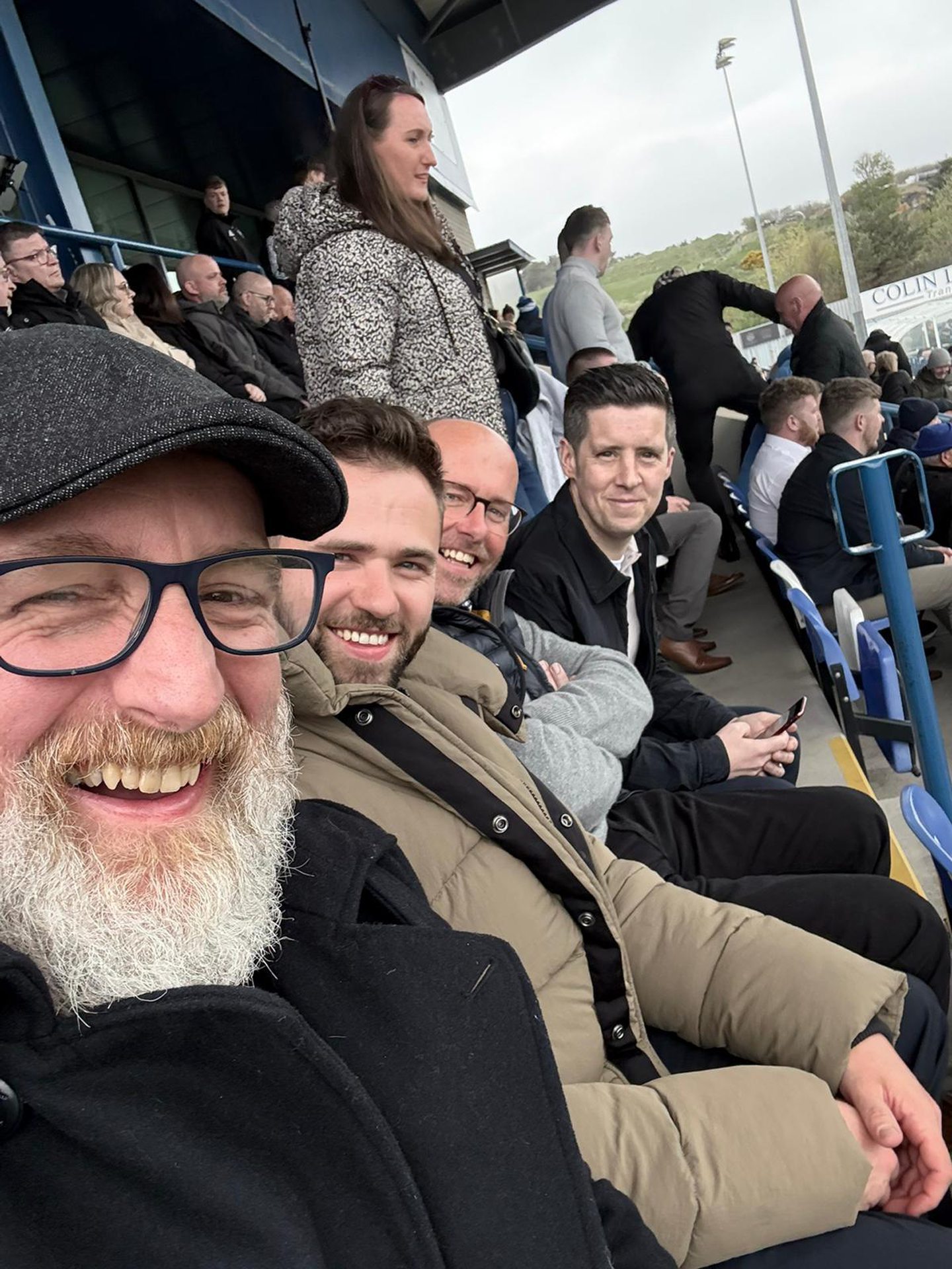 Four men take in a game at Cove Rangers' football ground.