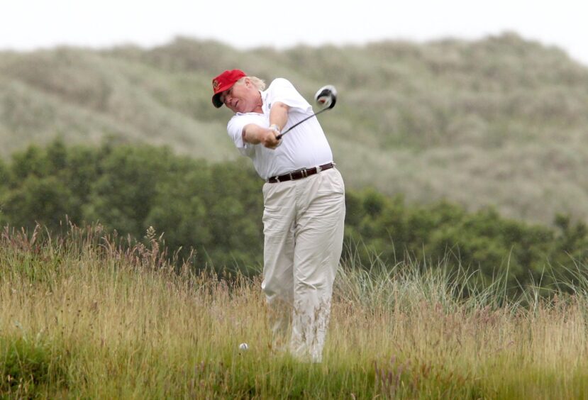 Donald Trump hits a tee shot on the tenth hole of the Trump International Golf Links golf course near Aberdeen 