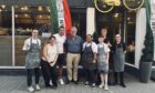 Christopher Nolan poses with staff at Pizzeria Planta.