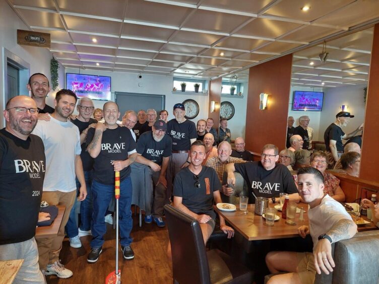 A large group of men, who took part of the Brave cancer event, meet at a restaurant.