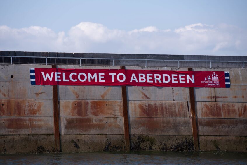 A 'Welcome to Aberdeen' sign adorns the harbour wall.