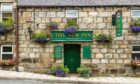 The exterior of The New Inn, with green signage.