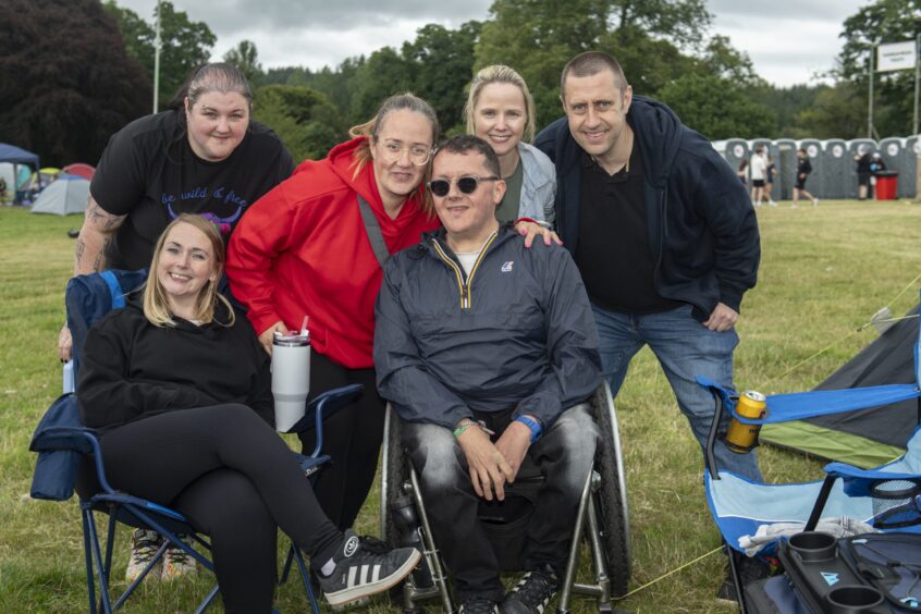 A group relaxes in portable chairs after getting their tents up and campsite organised for the weekend.