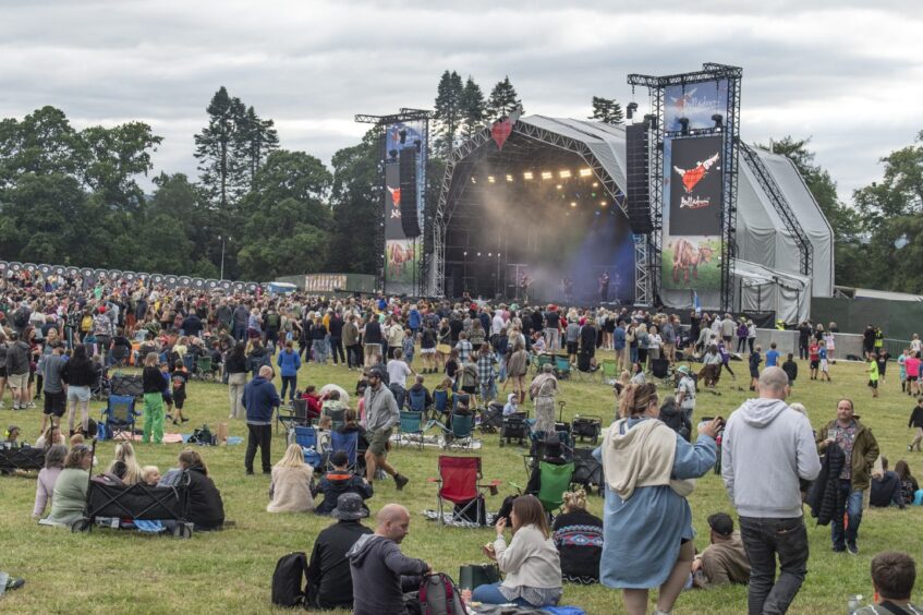 The crowd sits and stands to enjoy the music of Torridon on opening night.