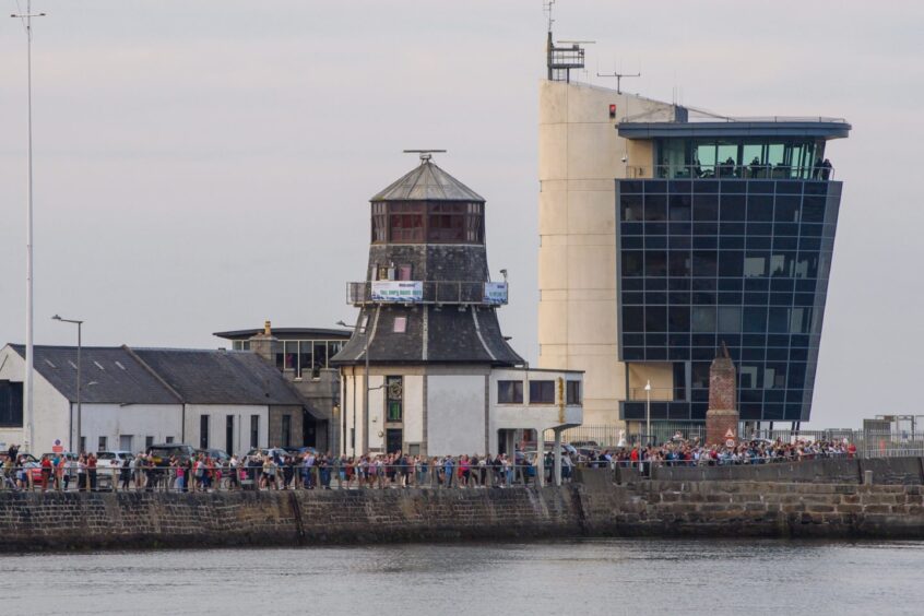 Crowds line the walls at Aberdeen harbour for the arrival of ships for the Tall Ships Races.