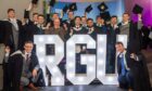 A jubilant group of graduates gather around the glowing RGU letters, marking the end of an unforgettable journey with cheers and caps held high.