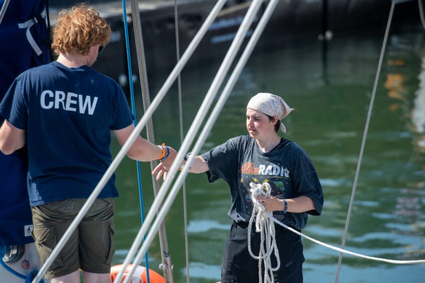 Crew members handling ropes aboard a tall ship docked in Aberdeen Harbour during the Tall Ships arrival.