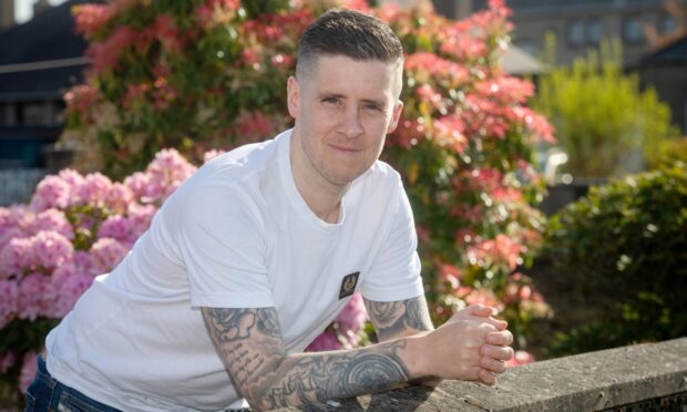 Greg Napier, part of the Brave 2024 event, poses against a wall.