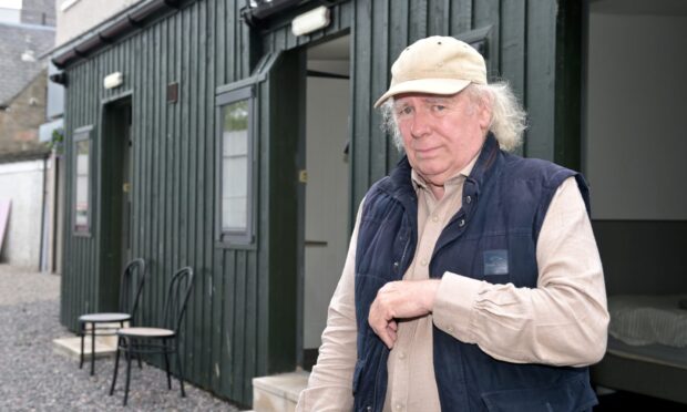 Donald MacLean, owner of Rooms in Inverness, stands in front of the wooden clad building that holds his single rooms.