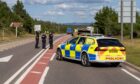 A police vehicle and officers on the A9 carriageway, which was closed after a serious crash.