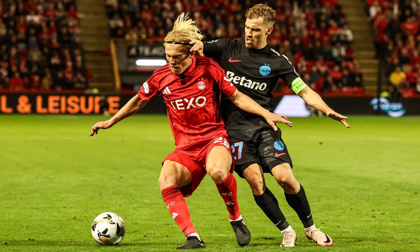 Aberdeen's Alexander Jensen and FCSB's Darius Olaru in action during a UEFA Europa League play-off at Pittodrie.
