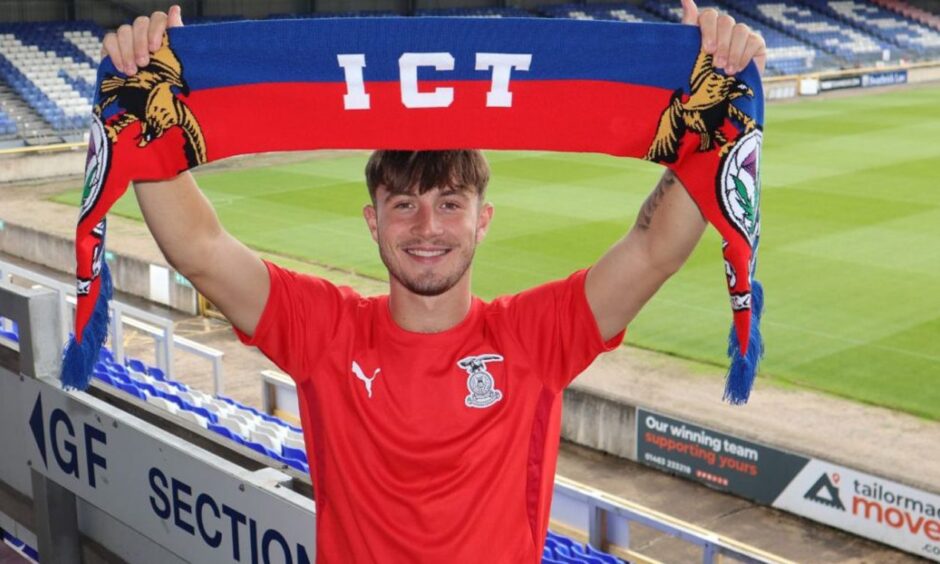 Alfie Bavidge holds a Caley Thistle scarf aloft.