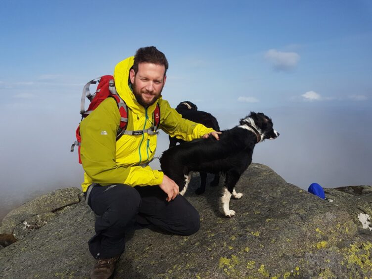 Graham McGowan on a hill walk with two collies. 