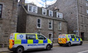 Two police vans outside a block of flats in Skene Street.