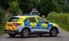 A police car in the middle of the road keeps drivers away from the site of a crash.