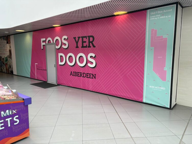 Pink boards around an empty shop unit with 'Foos Yer Doos Aberdeen' printed on it.