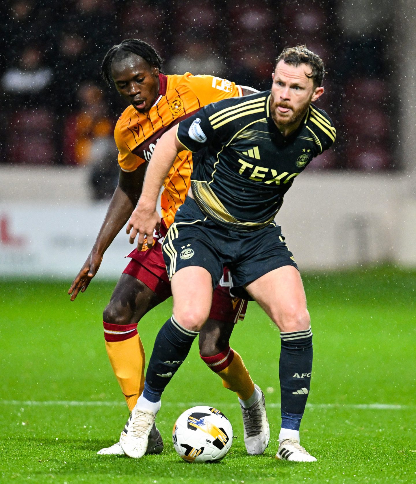 Aberdeen's Nicky Devlin (R) and Motherwell's Emmanuel Longelo in action . 
