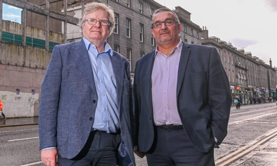 Two men stand side by side