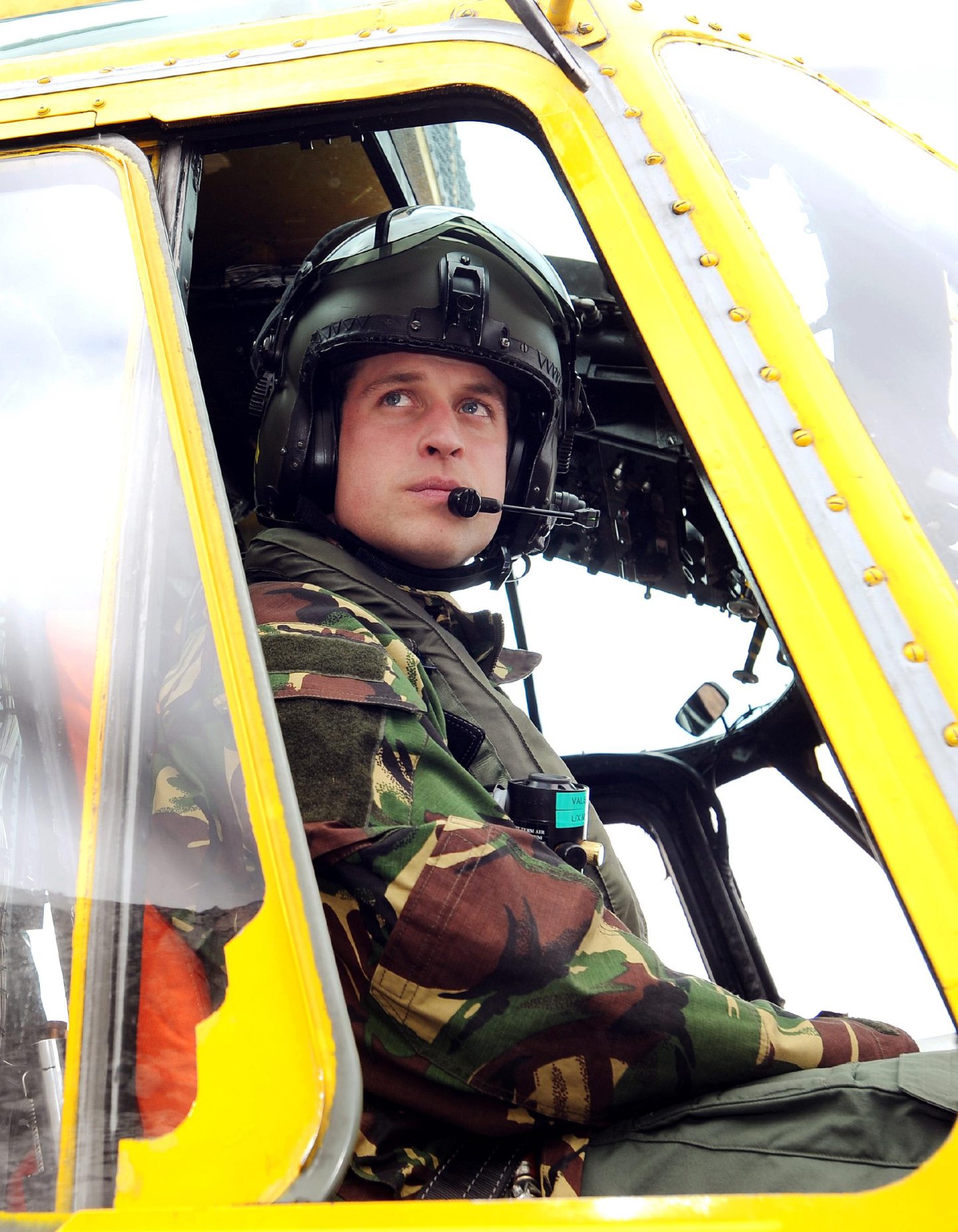 Prince William at the controls of a yellow search and rescue helicopter