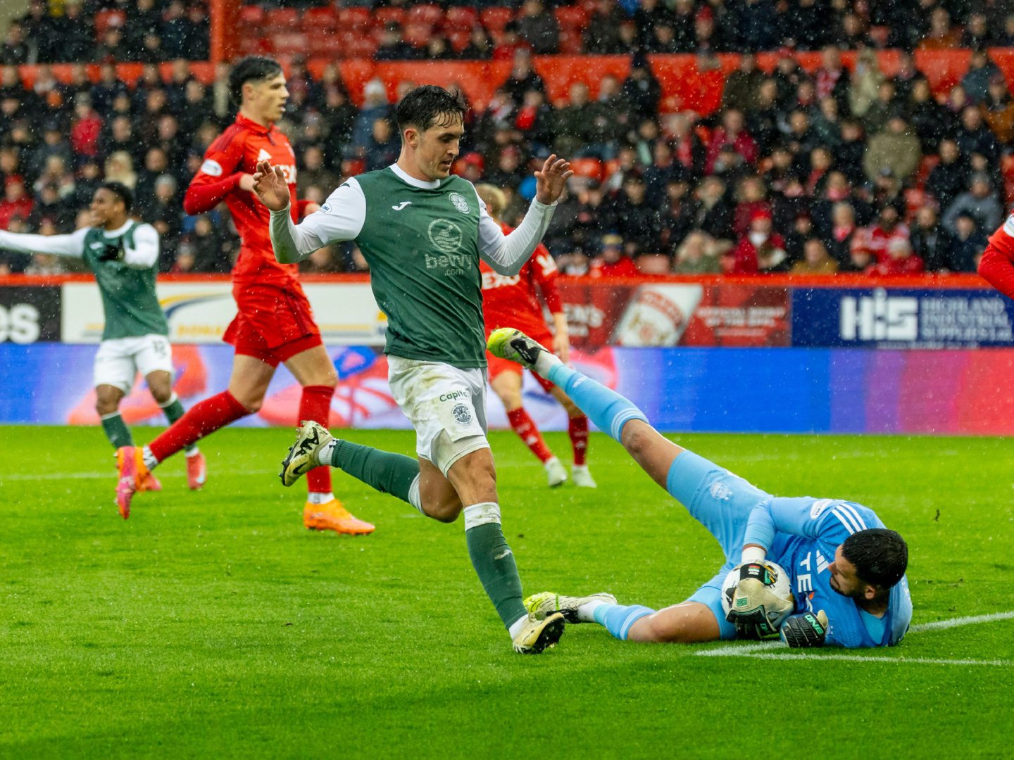 Aberdeen goalkeeper Dimitar Mitov saves at the feet of Jamie McGrath of Hibernian in a 2-1 loss at Pittodrie