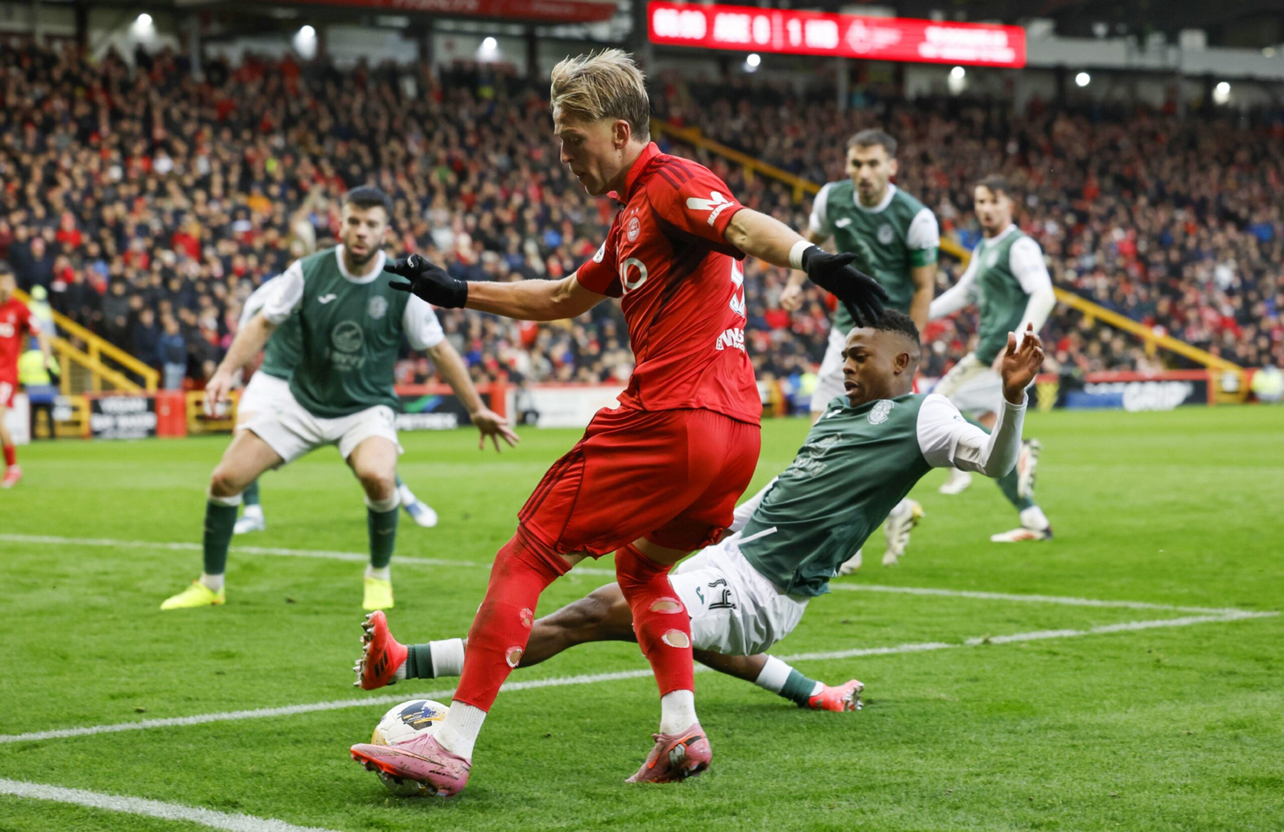 Aberdeen's Jesper Karlsson and Hibernian's Miguel Chaiwa in action.