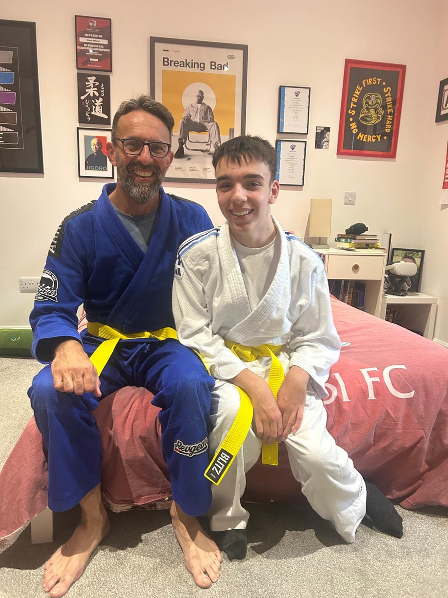 Steve and Liam in martial arts gear, both wearing yellow belts