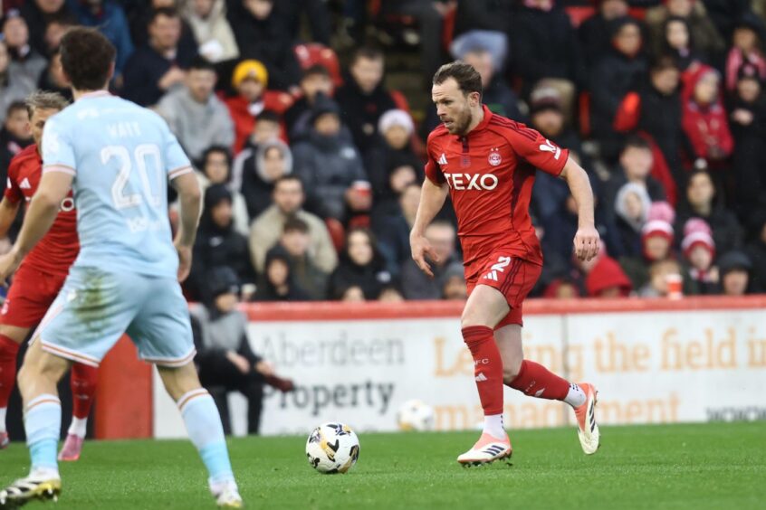 Nicky Devlin advances with the ball at his feet against Motherwell at Pittodrie