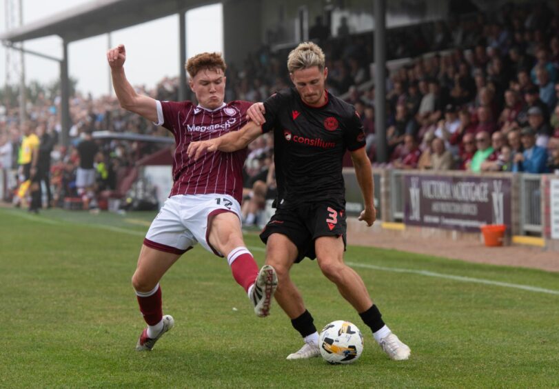 Findlay Marshall puts in a tackle out on the wing against St Mirren's Scott Tanser