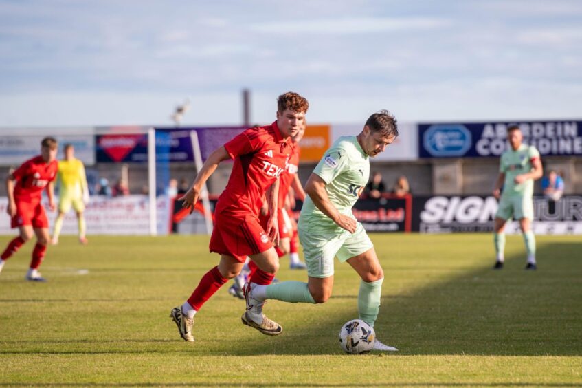 Marshall challenging Peterhead's Peter Pawlett during a sun-splashed Dons-Peterhead friendly in July