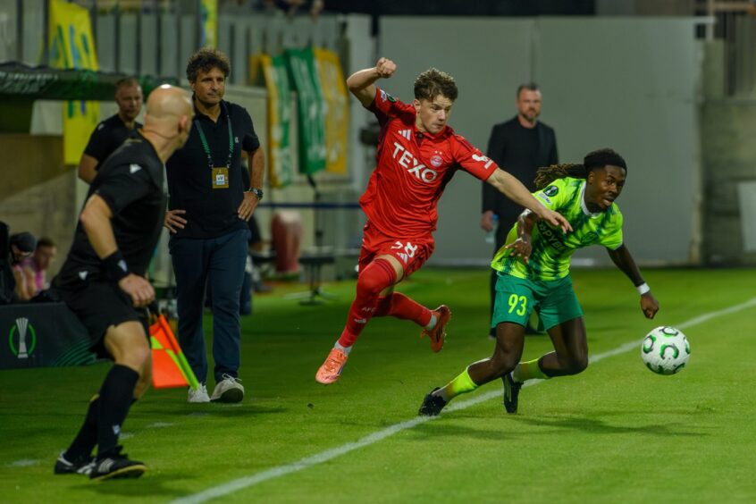Dylan Lobban is airborne as he takes on AEK Larnaca's Jeremie Gnali on the touchline