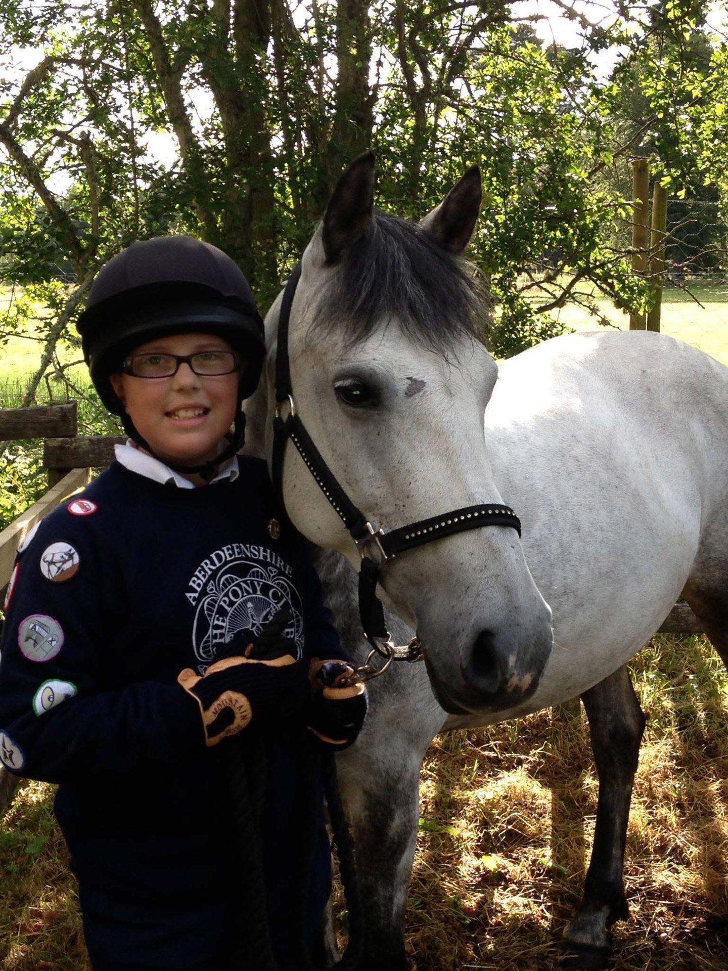 A young girl standing next to a pony